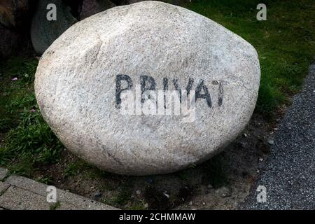 Bright granite erratic block with the faded inscription private to mark the end of the public area Stock Photo