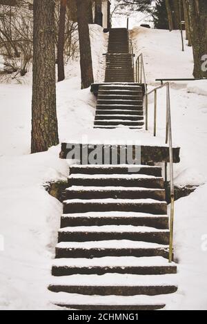Winter. Stairs. People walk on a very snowy stairs. Uncleaned icy stairs in front the buildings, slippery stairs Stock Photo