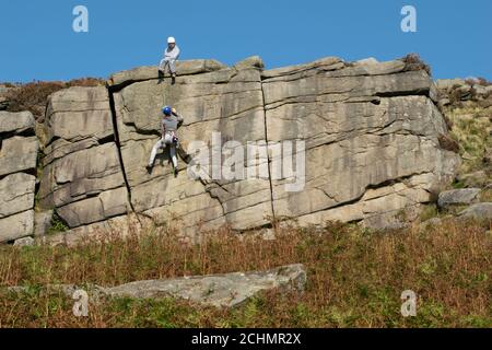 Rock climbing on Burbage Edge gritstone in the Peak District National Park, Hathersage. Derbyshire, UK. Stock Photo