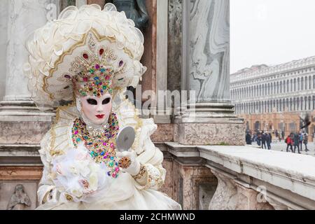 Venice, Veneto, italy  - woman in costume at the Venice Carnival  posing on the St Marks Cathedral bell tower with view to Piazza San Marco Stock Photo