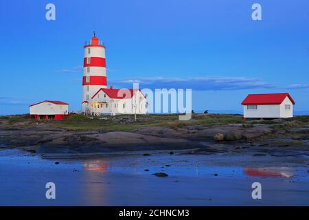 Pointe-des-Monts Lighthouse at dusk with reflections in the sea, Cote-Nord, Quebec Stock Photo