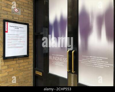 The entrance to the Donmar Warehouse theatre in London's West End with a notice advising of COVID19 compliance measures taken for socially distanced performances of BLINDNESS in September 2020. Stock Photo