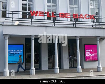 The Old Vic theatre in London, closed since 16th March 2020 as a result of the COVID-19 pandemic. A neon sign and digital display proclaim ‘We’ll be back’ Stock Photo