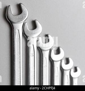 Spanners. Many wrenches. Grey background. Set of wrenches in different sizes on grey background.Square format. Stock Photo