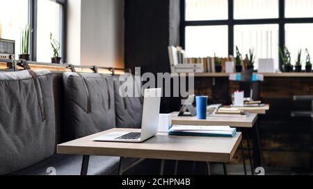Laptops on desks in empty modern office. Stock Photo