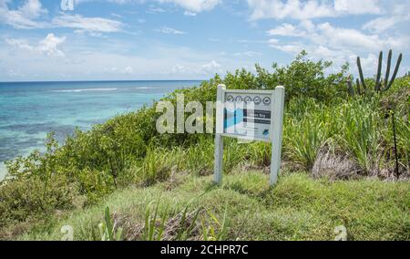 Christiansted, St. Croix, US Virgin Islands-July 3,2014: Sign at Isaac Bay with lush greenery overlooking the Caribbean Sea on St. Croix Stock Photo