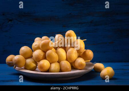 Dates or date palm in wood bowl on wooden background.. Stock Photo