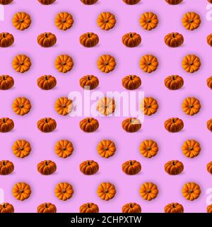 Seamless pattern with bright orange and brown round textured pumpkins on pink background. Directly above and high angle view on pumpkins. Stock Photo