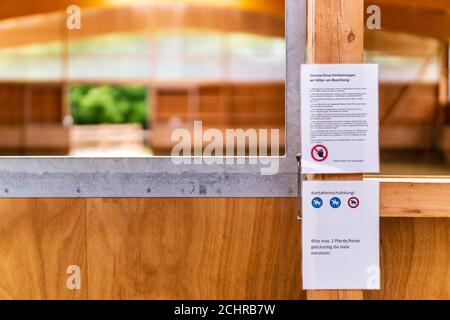 North Rhine-Westphalia, Germany - June 27, 2020: Sign with Corona virus (COVID-19) restrictions and rules of conduct hanging at an indoor riding arena Stock Photo