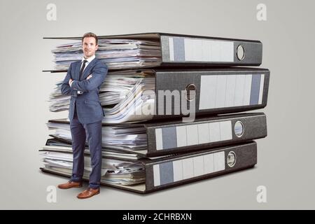 Accountant in front of oversized folders full of paperwork Stock Photo