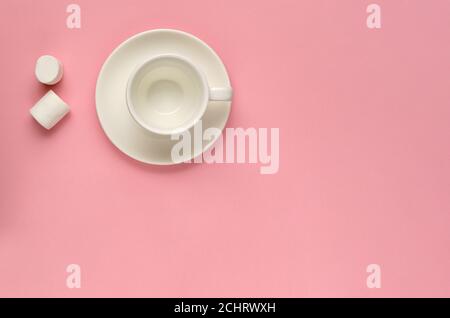 Clean empty white coffee cup with saucer and two marshmallows on pink background. Minimal template for feminine blog, social media, networks Stock Photo