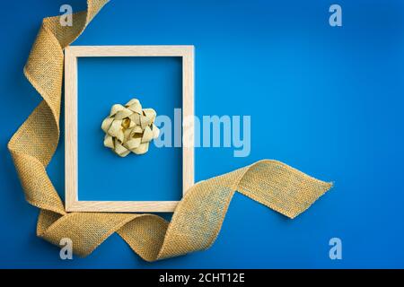 concept new year. golden bow framed on a blue background Stock Photo
