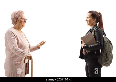 Elderly woman with a walking cane standing and talking to a female student isolated on white background Stock Photo