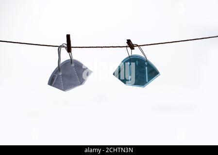 Face mask are hanging from rope on isolated white background Stock Photo