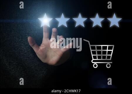 The concept of assessment. Hand pointing to five stars to increase the company's rating, increase the rating. The client's hand gives a five-star rati Stock Photo