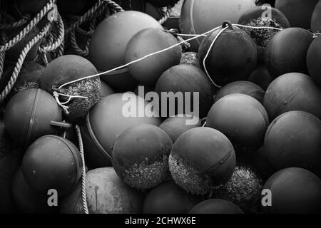 Spherical plastic floats of fishing nets lay in port. Black and white photo Stock Photo