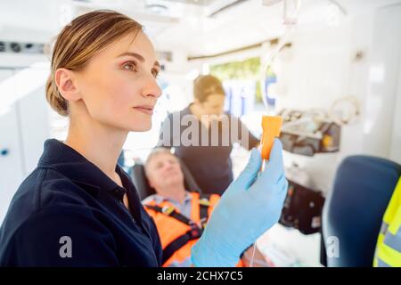 Paramedic looking after the drop injection in an ambulance Stock Photo