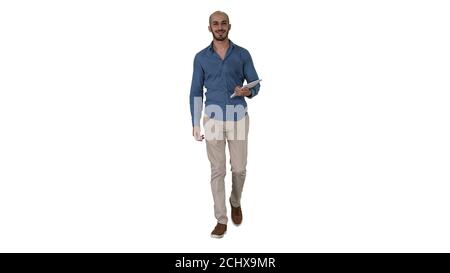 Arab presenter walking with digital tablet swiping pages on it on white background. Stock Photo