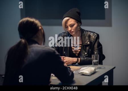 cute drug dealer being questioned at police station. Stock Photo