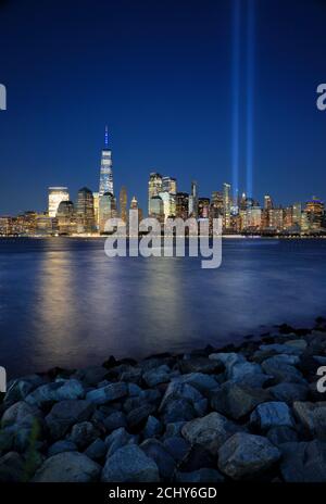 The night view of Lower Manhattan skyline with annual 9/11 tribute lights projecting into sky with Hudson River in foreground from Liberty State Park.New Jersey.USA Stock Photo