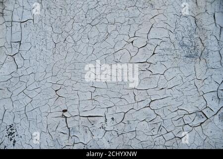 Cracked flaking gray paint on monastery wall, background texture. Surface with old weathered peeling grey paint . Stock Photo