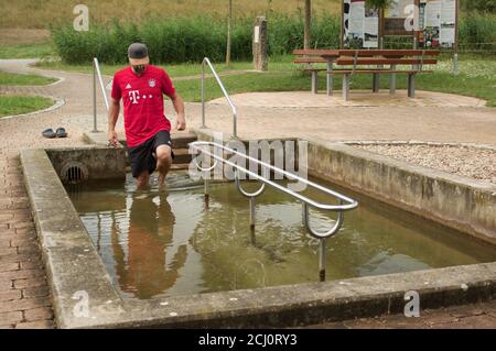 Man wading in kneipp cold water pool, Franconia, Germany Stock Photo
