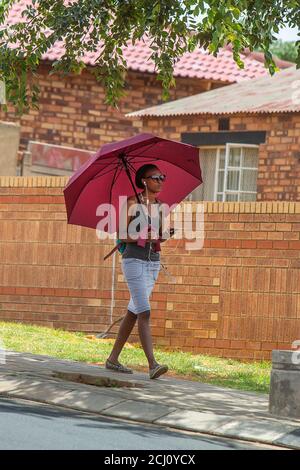 Young African female walking on Vilakazi street in Soweto Township, South Africa Stock Photo