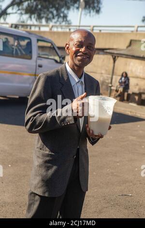 African male drinking Umqombothi - a South African beer made from maize Stock Photo