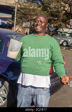 African male drinking Umqombothi - a South African beer made from maize Stock Photo