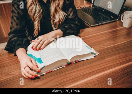 Female student reading a book and studying for the exams Stock Photo