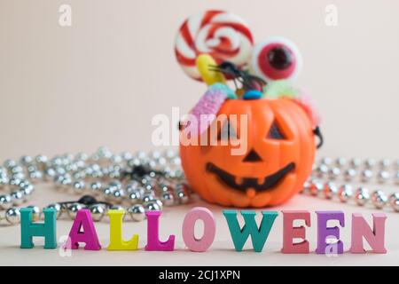 Inscription heluin on the background of pumpkins with candy. Stock Photo