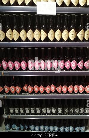 Display shelf of many Dutch craft beer bottles with colorful labels Stock Photo