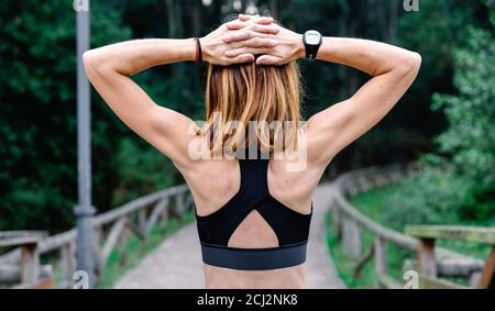 Unrecognizable sportswoman doing stretching arms outdoors Stock Photo