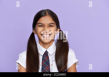 Funny positive indian kid primary school girl laughing isolated on background. Stock Photo