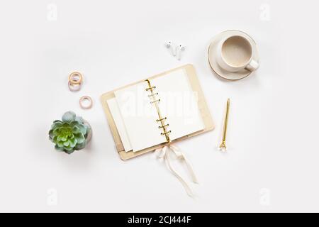 Minimal office desk table with stationery set, coffee cup, earphone and green plant in a pot. Stock Photo