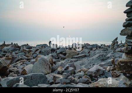 Stacked pebbles on the beach at sunset, Morro Bay State Park, California Stock Photo