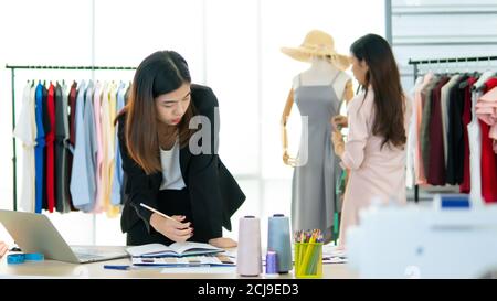 Portrait of Asia young designer working in the garment store Stock Photo
