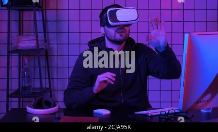Young handsome man wearing virtual reality glasses manipulating Stock Photo