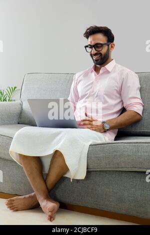 Man working from home and attending an office meeting on video call Stock Photo
