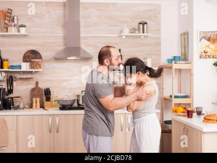 Violent husband shaking wife during disagreement at breakfast. Domestic violence threatening aggressive angry frustrated husband abusing physical depressed sad unhappy crying stressed woman Home abuse Stock Photo