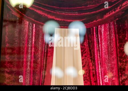 red velvet theater curtains through the window. Lights reflection on the glass. Stock Photo