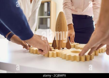 Entrepreneurs at office desk with rocket and gearwheels as metaphor of working on company strategy Stock Photo
