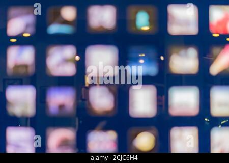 Defocused abstract multicolored bokeh lights background. Square windows at night Stock Photo