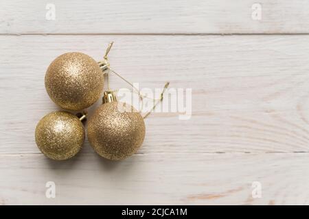 New year and Christmas background - three golden balls on wooden background. top view, minimal flat lay Stock Photo