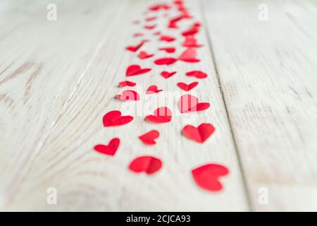 Plenty of cut out paper red hearts on wooden backround, perspective,  selective focus Stock Photo