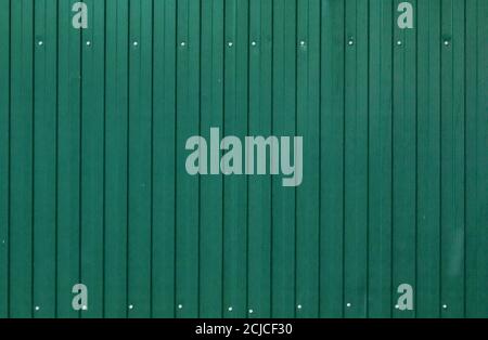 Background of painted corrugated tin iron with galvanized screw heads and vertical orientation. Stock Photo