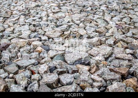 Background of gray stones at a road repair construction site as a drainage layer for paving asphalt. Stock Photo
