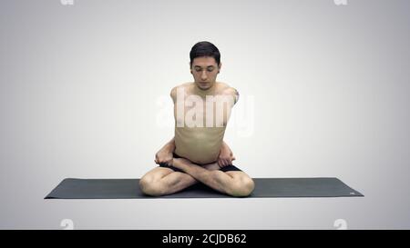 Sporty beautiful young man practicing yoga, sitting cross-legged Stock Photo