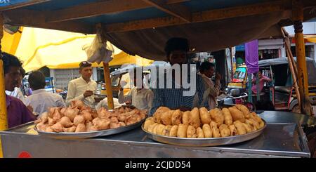 DISTRICT KATNI, INDIA - SEPTEMBER 24, 2019: an indian food seller displayed fresh vada samosa at street food carriage shop in market street. Stock Photo