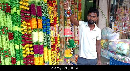 DISTRICT KATNI, INDIA - SEPTEMBER 24, 2019: An indian salesman presenting home decoration item at local store in asian street bazaar. Stock Photo